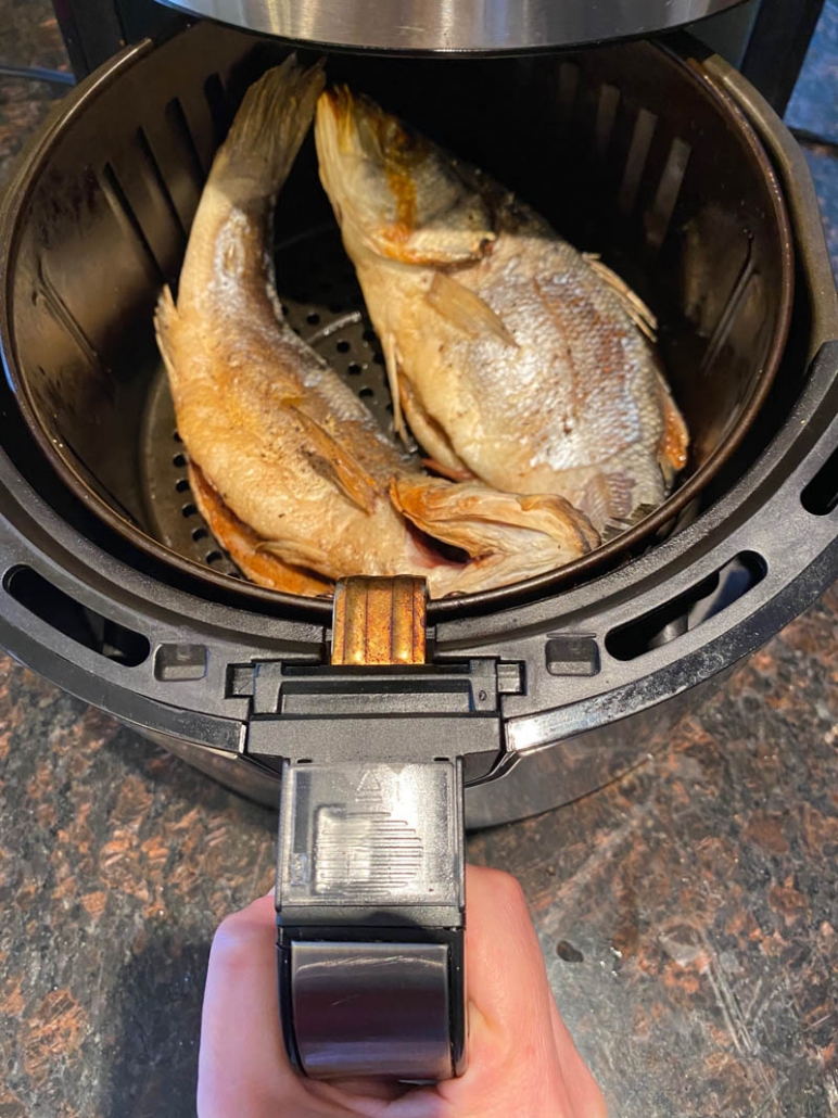 cooked air fryer fish in an air fryer basket