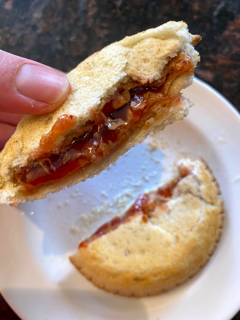 eating a peanut butter and strawberry jelly uncrustable 