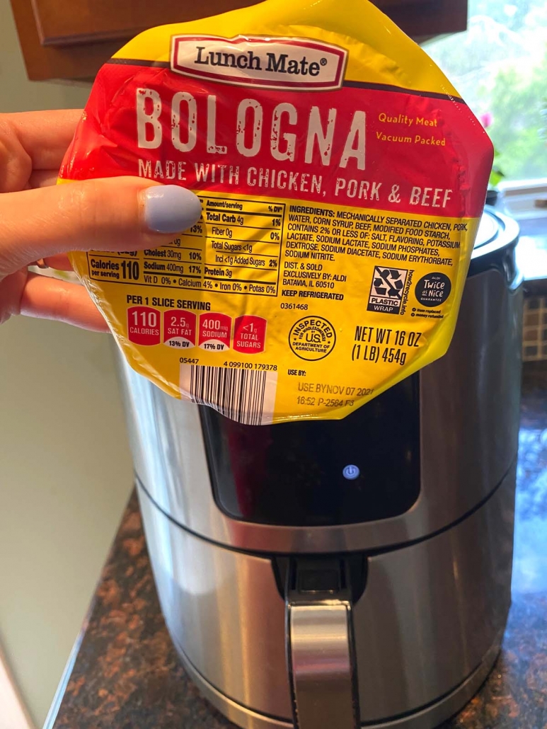 package of bologna held in front of air fryer