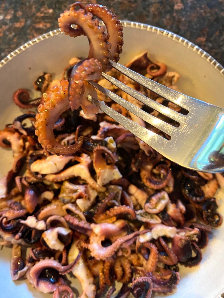 fork holding grilled baby octopus