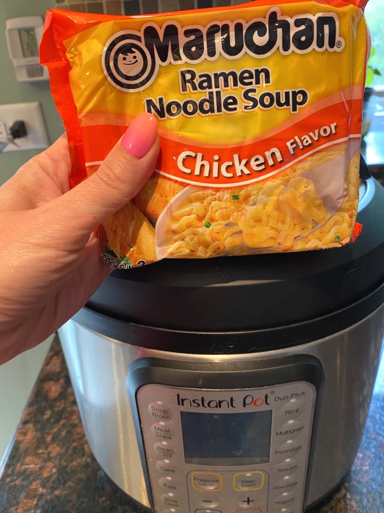 package of ramen held in front of instant pot