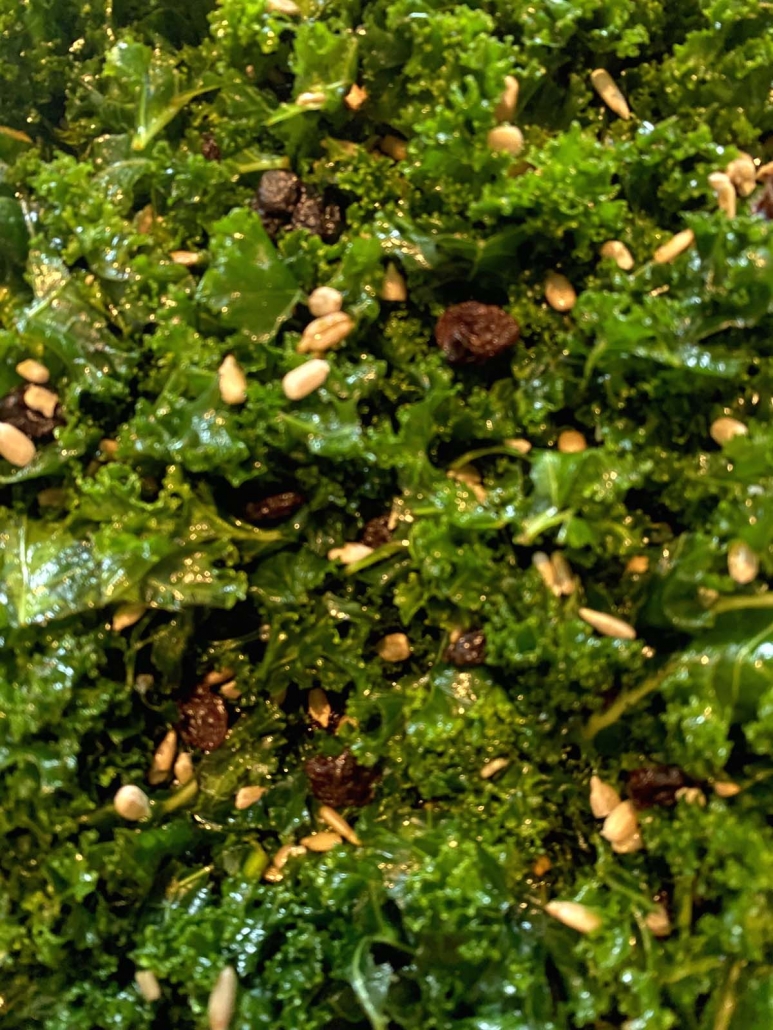 close up of kale salad with raisins and sunflower seeds