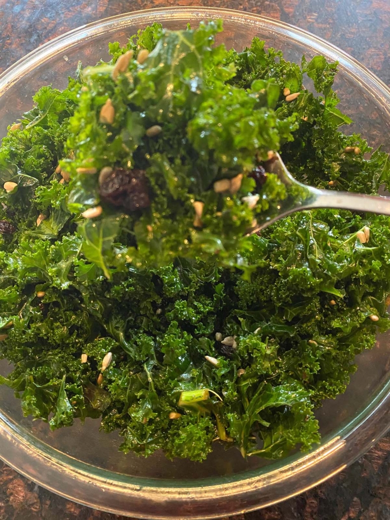 kale salad with seeds and raisins in bowl