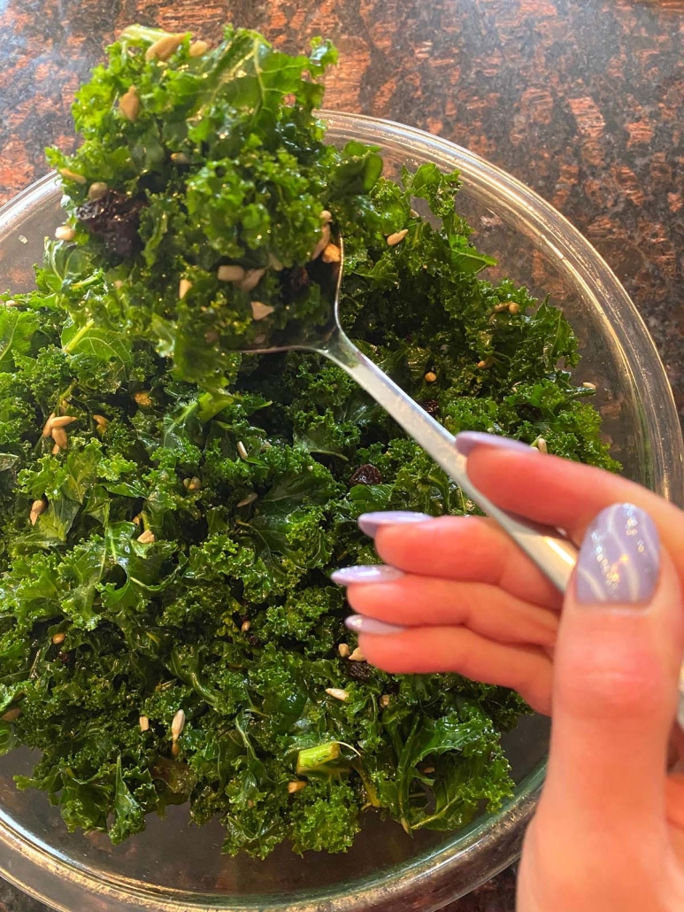 kale salad in bowl and stirred with spoon