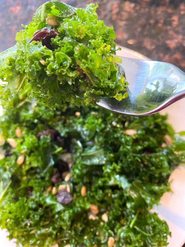 kale salad on plate with spoon