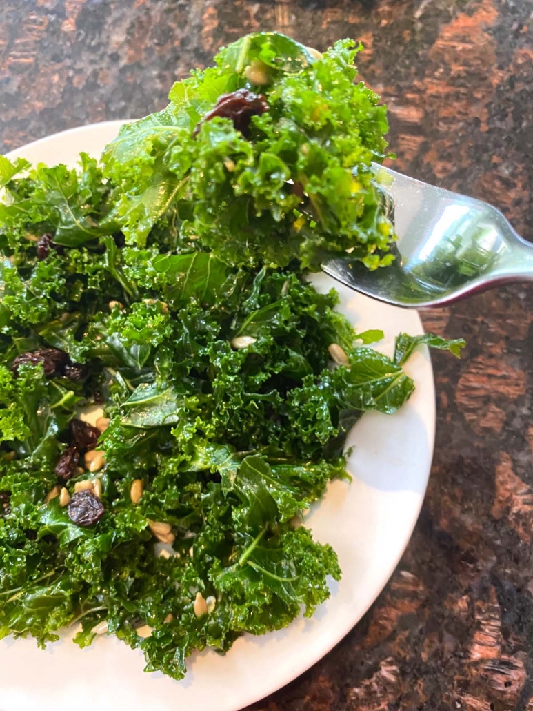 kale salad on plate with spoon