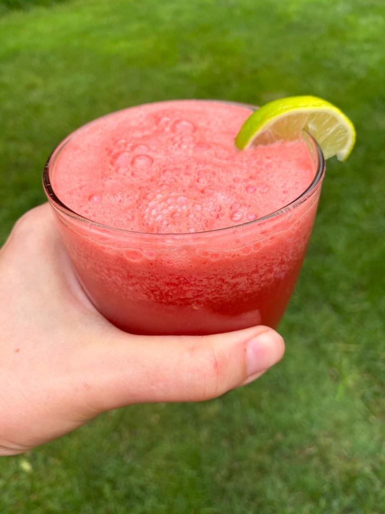 hold holding watermelon smoothie in a glass