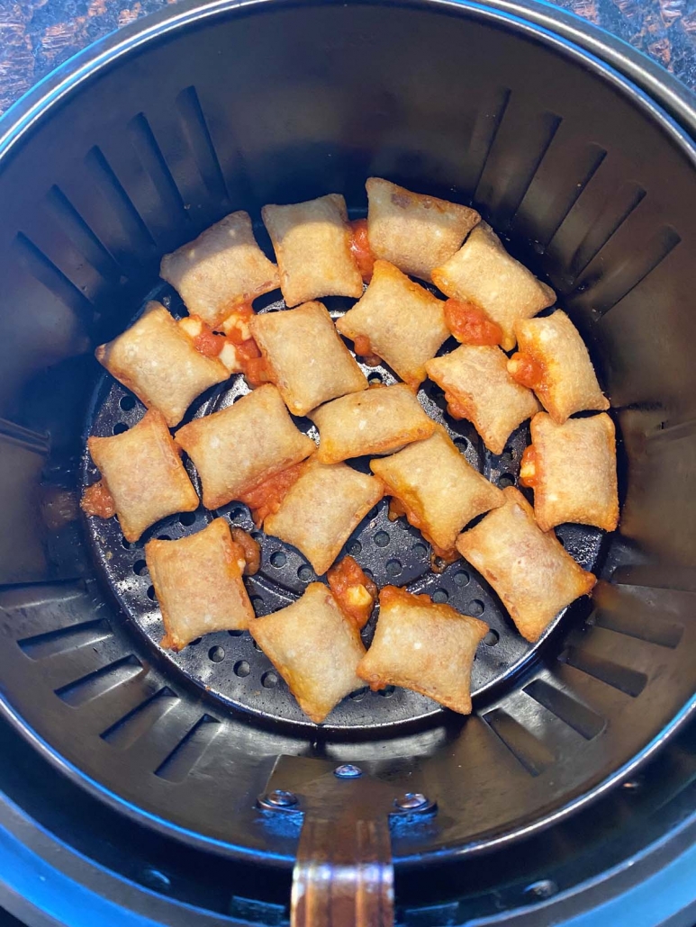 air fryer basket filled with cooked pizza rolls