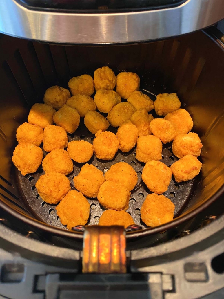 air fryer basket filled with popcorn chicken