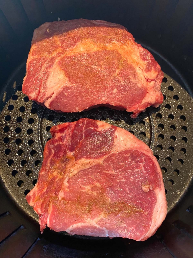 two seasoned ribeye steaks in air fryer 