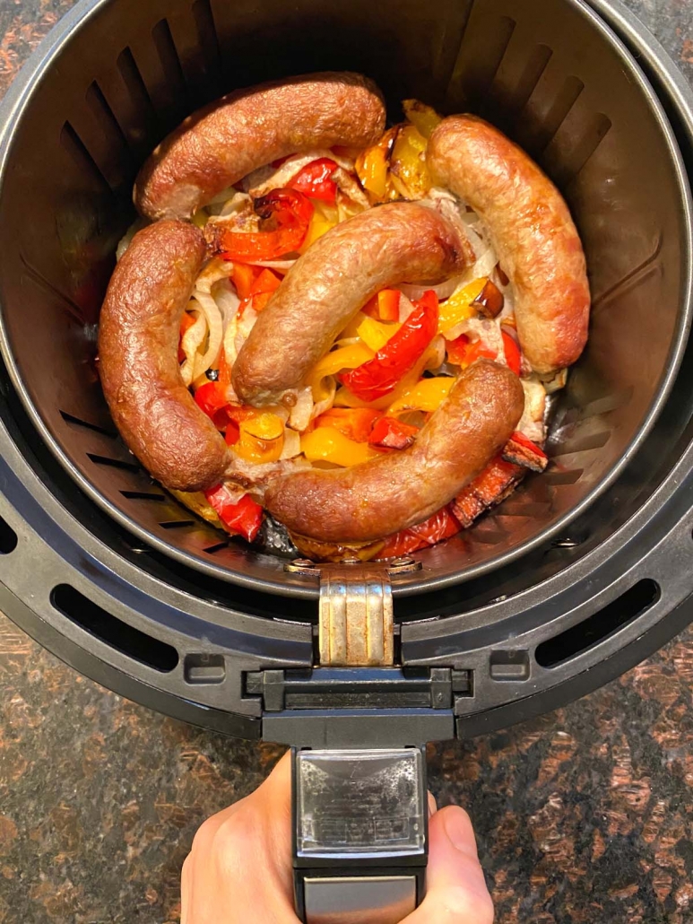 roasted sausages and peppers in an air fryer basket 
