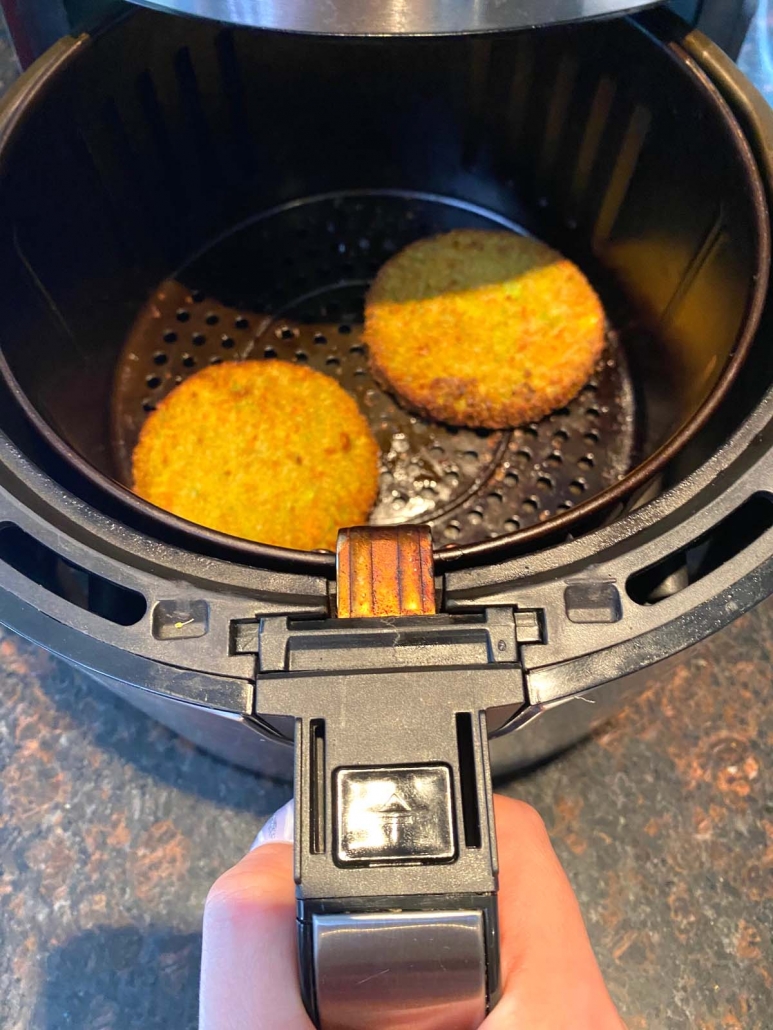 two veggie burgers in air fryer basket