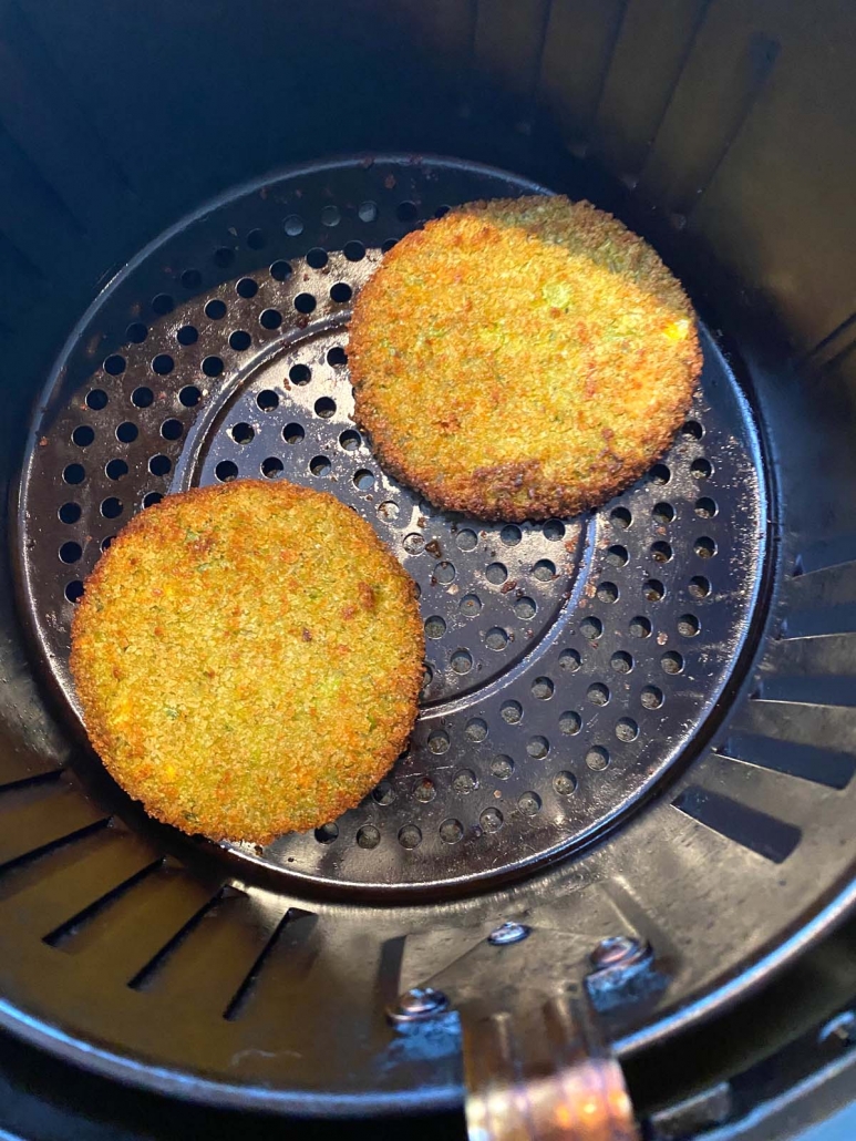 two cooked veggie burgers in air fryer