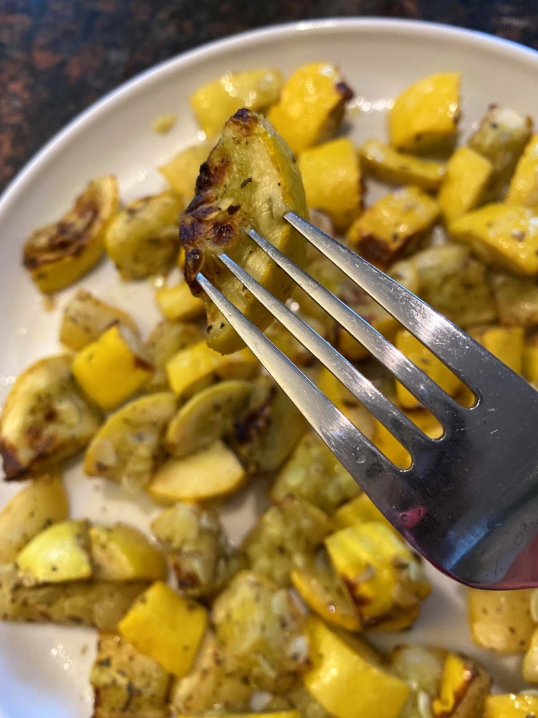 eating yellow summer squash with a fork