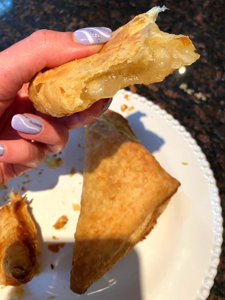 hand holding bitten apple turnover