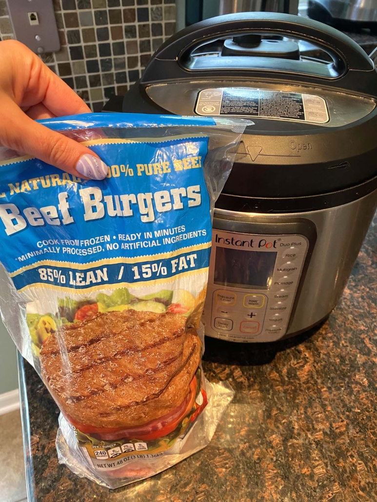 package of frozen beef burgers held in front of instant pot