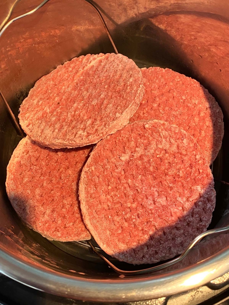 close up of frozen burgers in instant pot