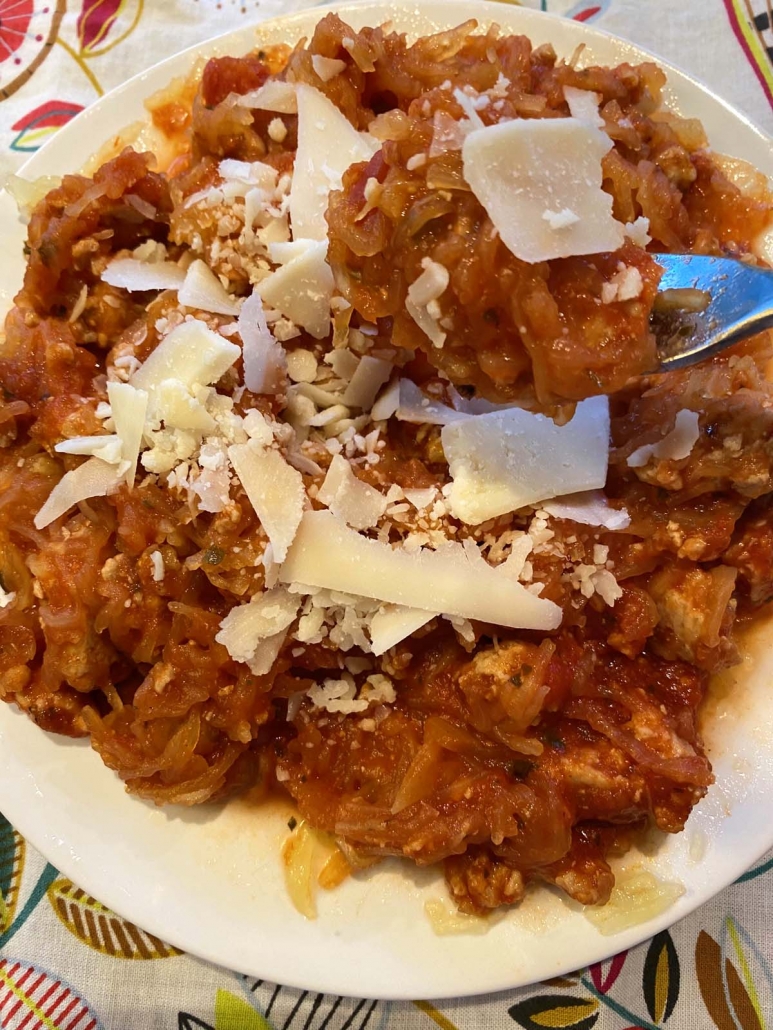 fork holding some spaghetti squash with meat sauce and parmesan on top