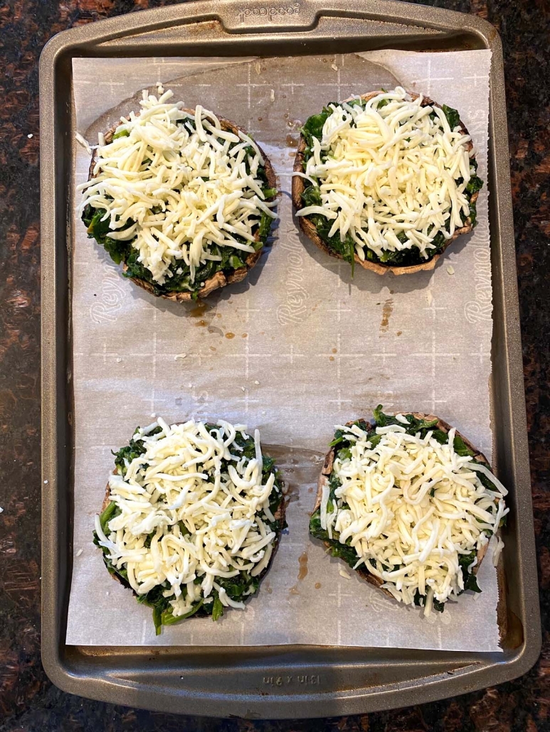 Portobello mushroom caps stuffed with spinach mixture and topped with shredded mozzarella cheese.