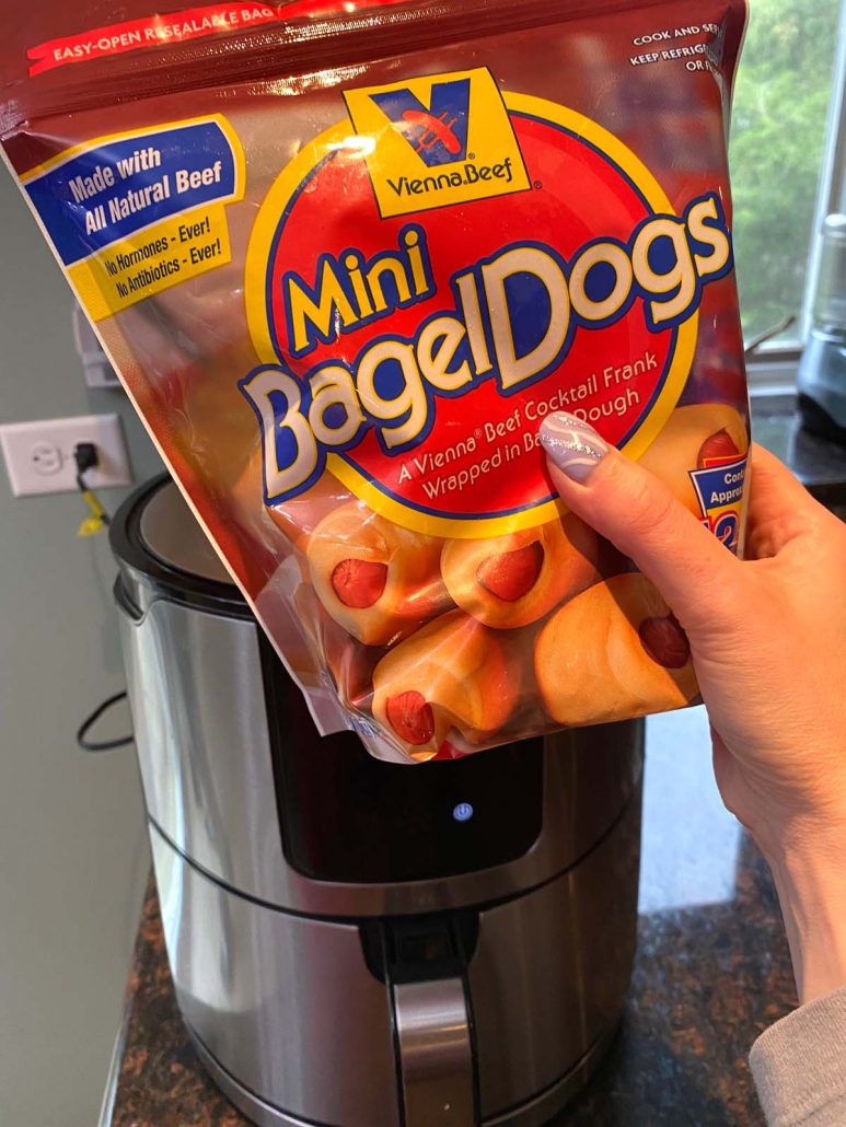 package of frozen mini bagel dogs held in front of the air fryer