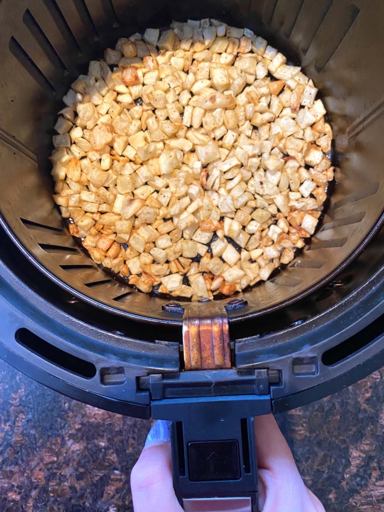 air fryer basket with diced potatoes