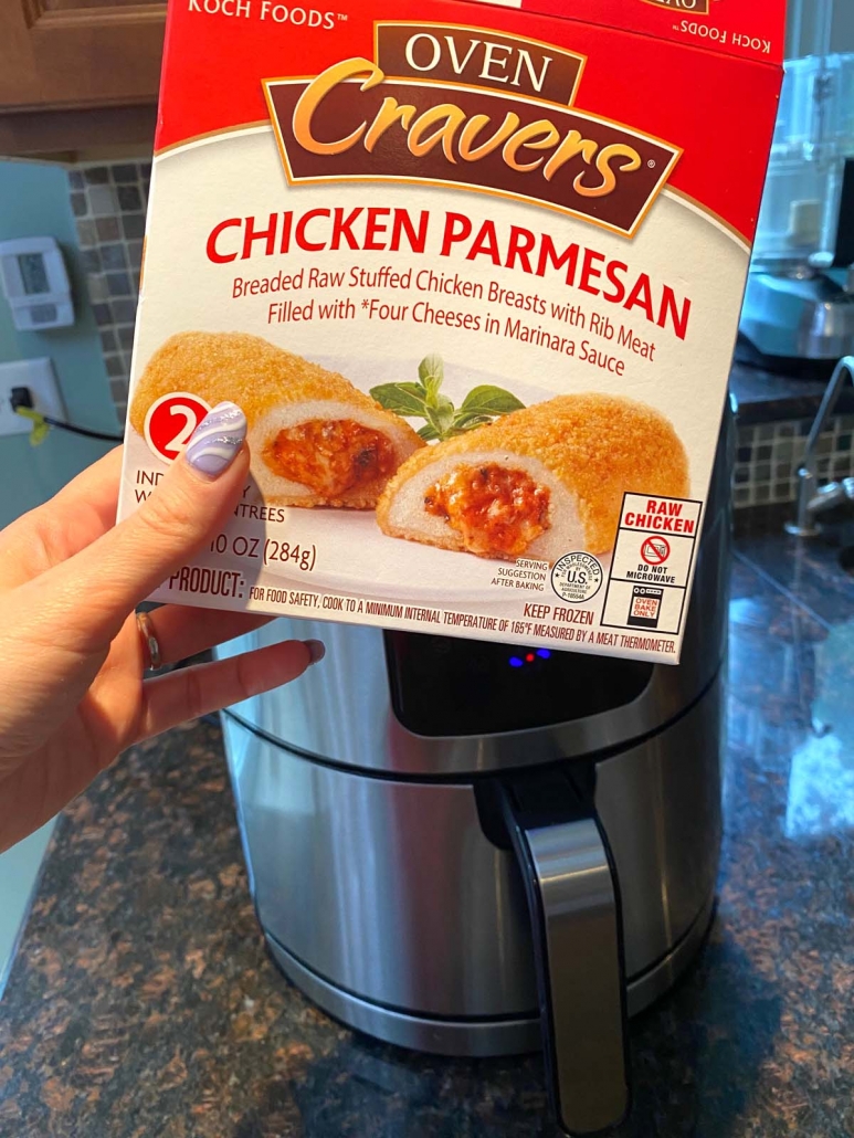 hand holding box of frozen chicken parmesan in front of air fryer