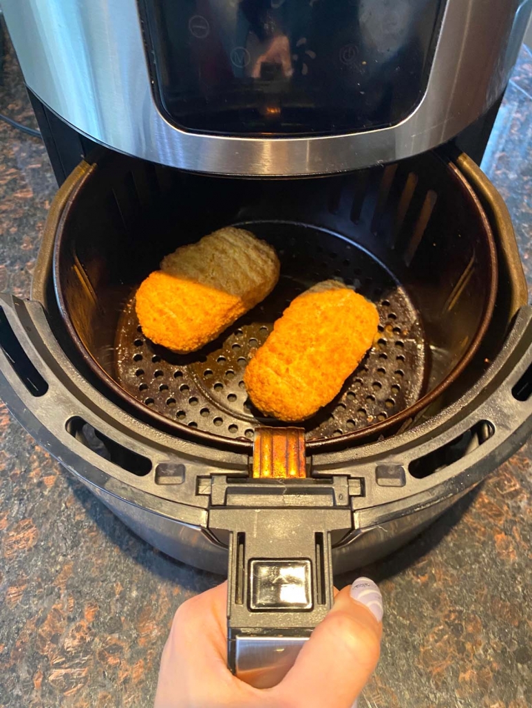 two chicken parmesan servings in the air fryer basket