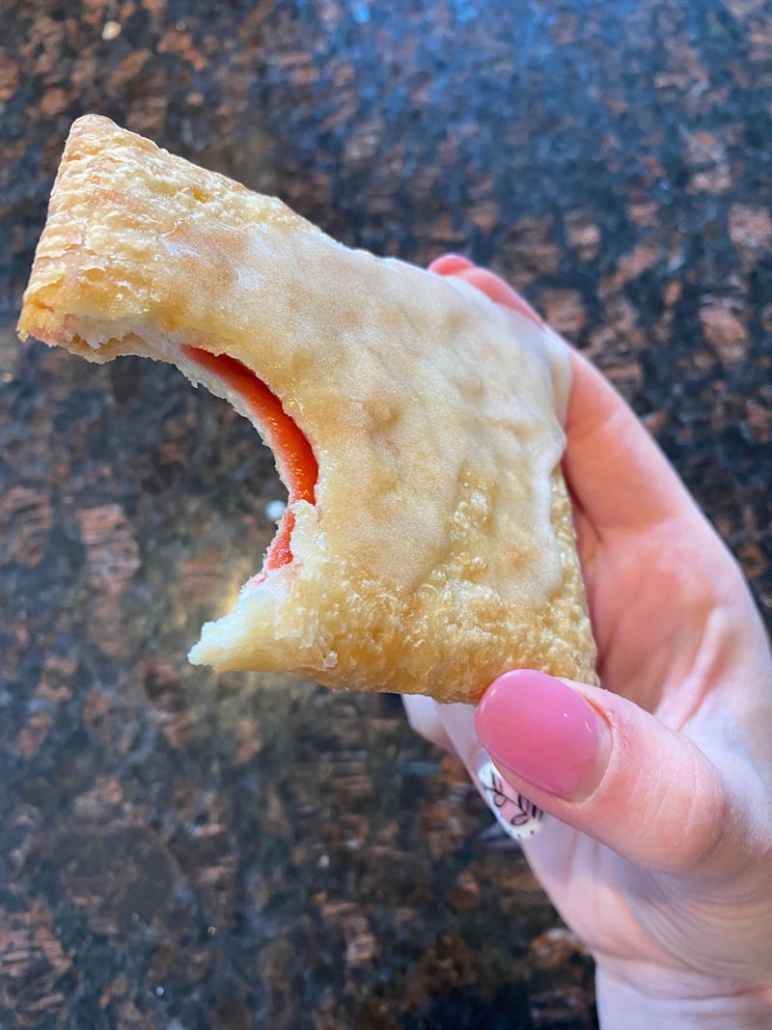 hand holding toaster strudel with bite taken out