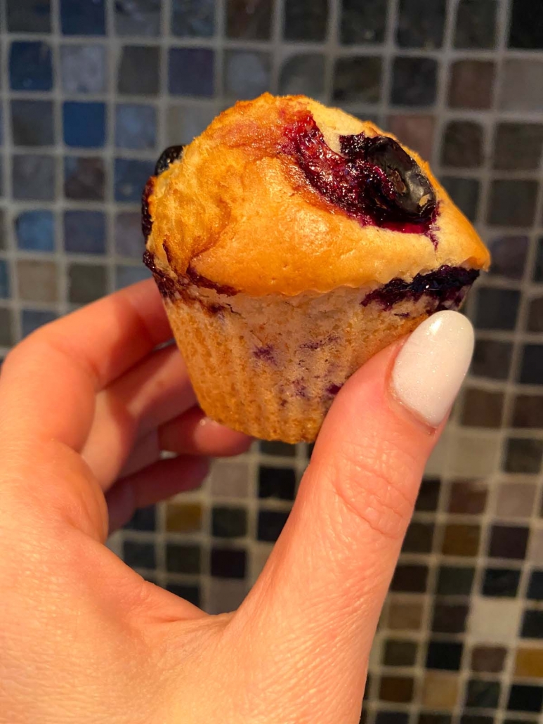 hand holding single air fried blueberry muffin