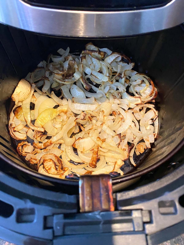 air fryer basket with cooked fried onions