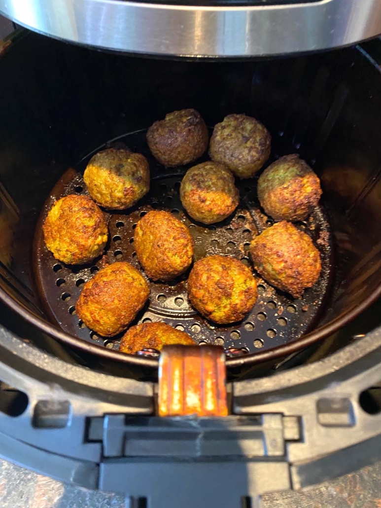 close up of frozen falafel cooking in the air fryer