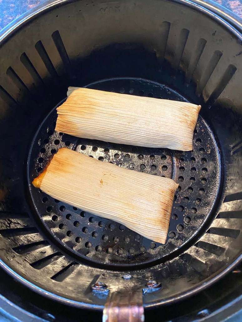 two beef tamales cooking in the air fryer