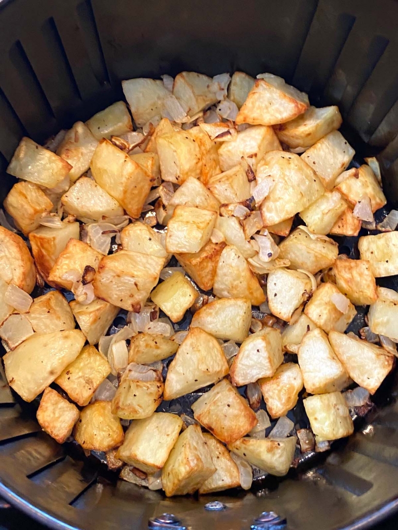 close up of potatoes and onions in the air fryer