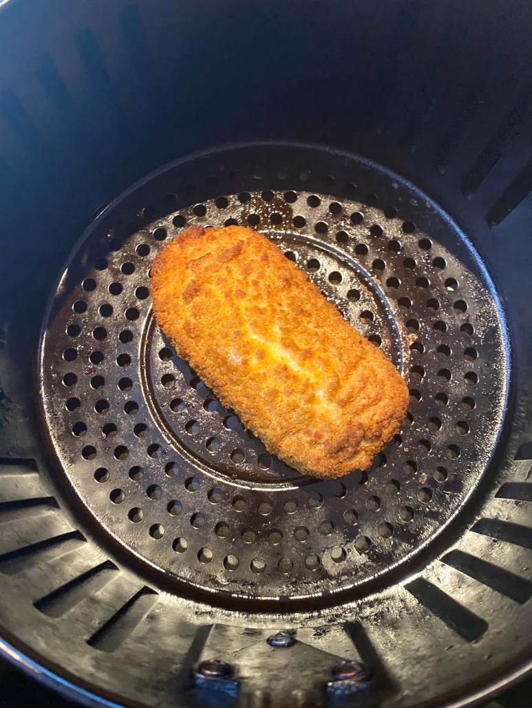 chicken kiev cooking in the air fryer basket close up
