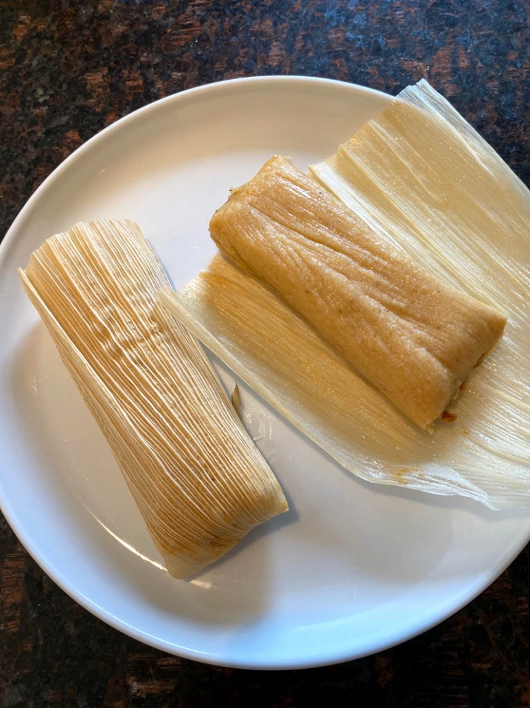 tamales on plate being unwrapped from husk