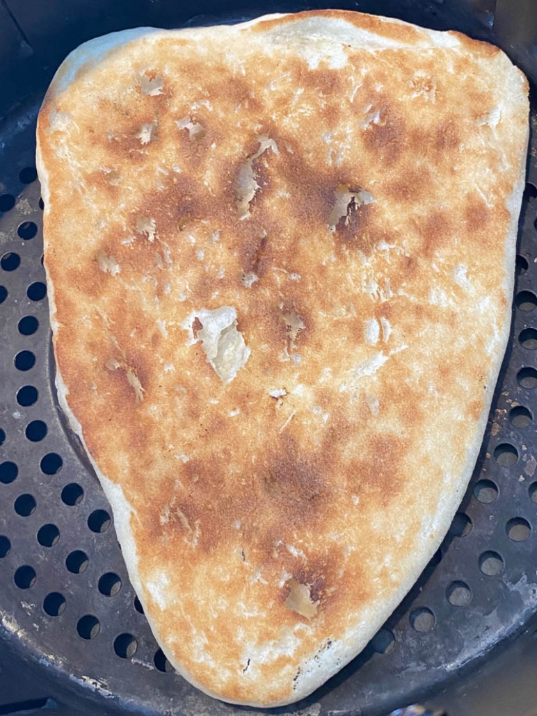 close up of naan bread cooking in the air fryer