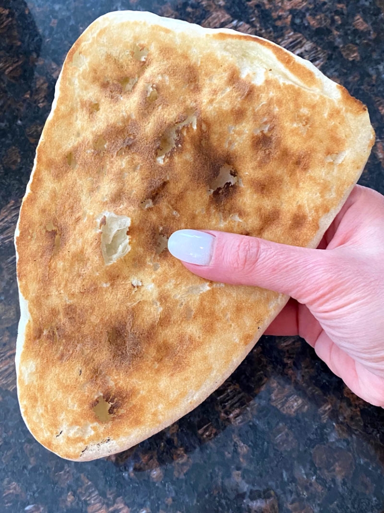 hand holding cooked naan bread