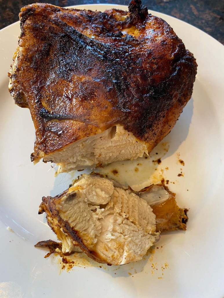 air fried bone-in chicken breast on a plate with slices removed