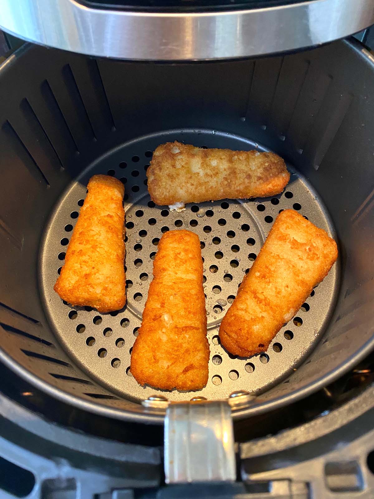 Cooked beer battered fish fillets in an air fryer.