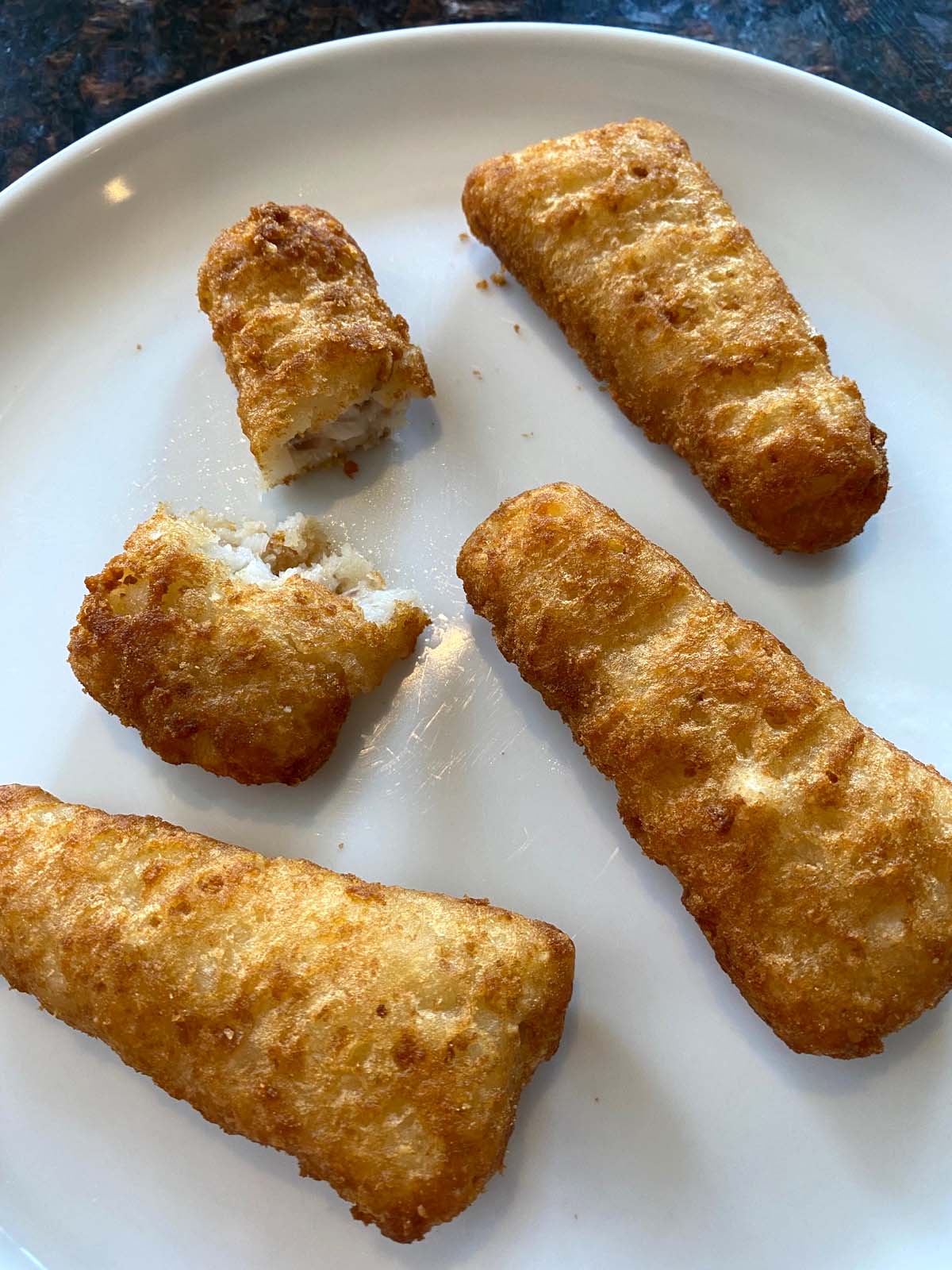 Cooked beer battered fish fillets on a plate.