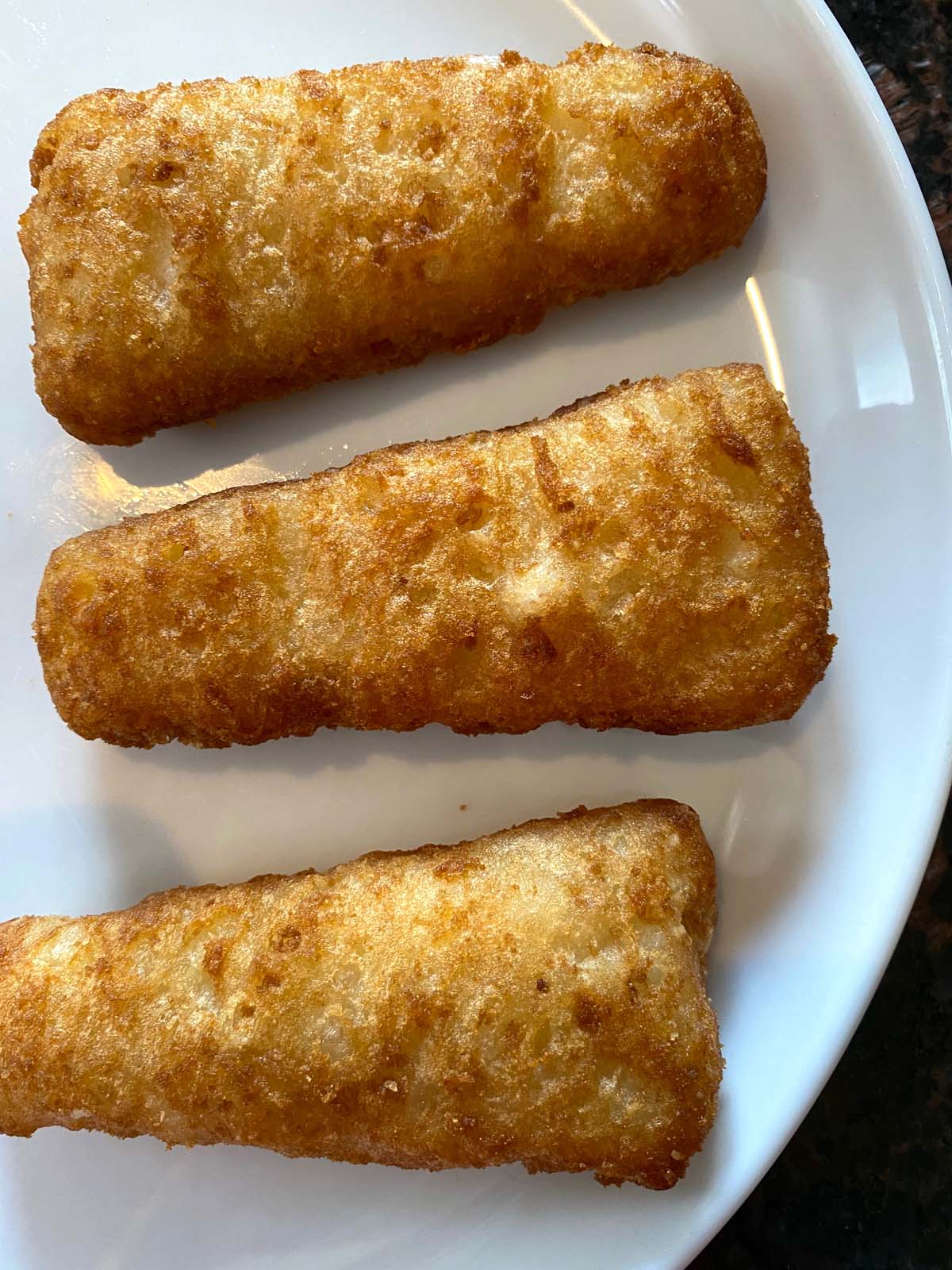 Cooked beer battered fish fillets on a plate.