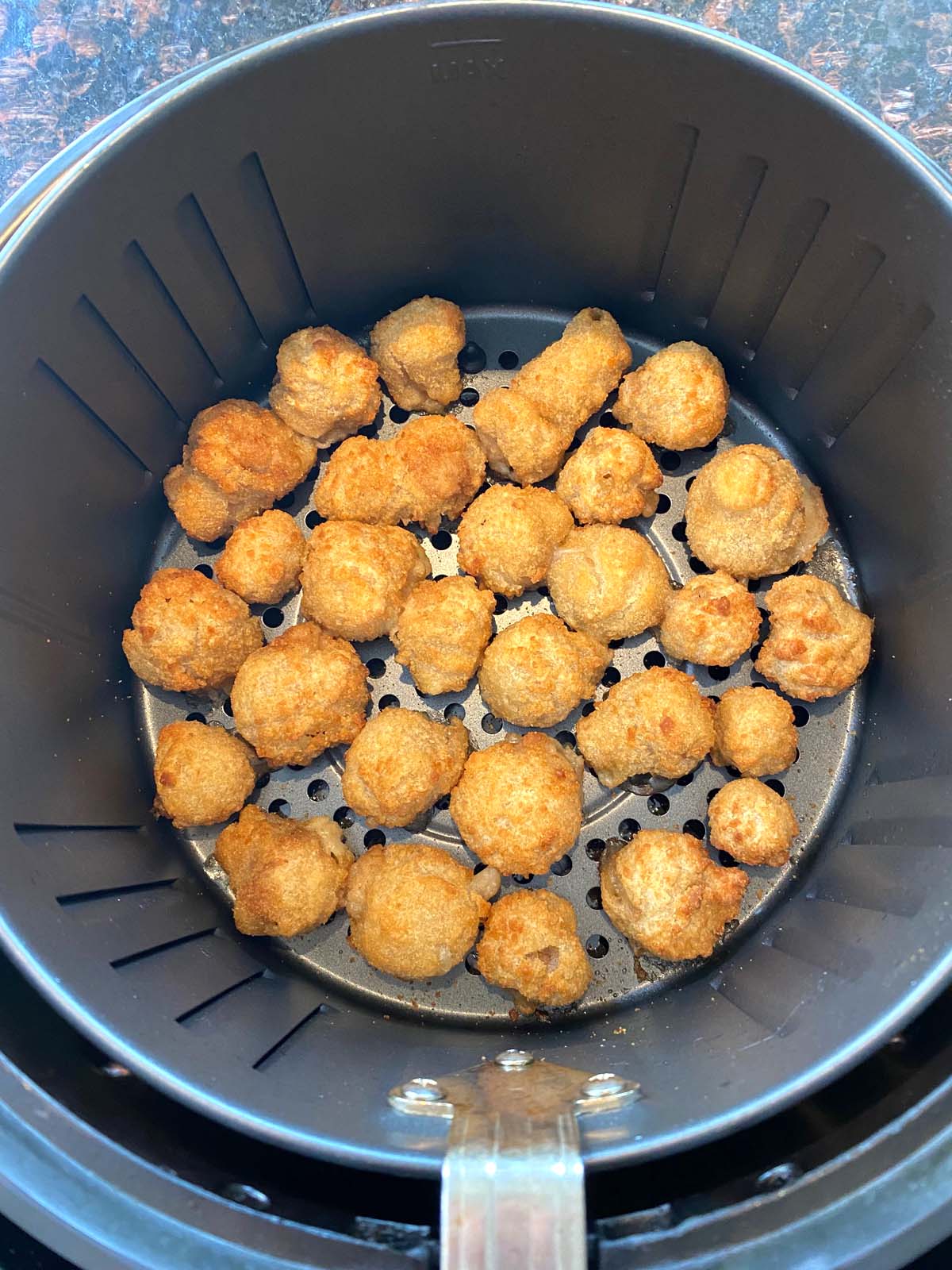 Cooked breaded mushrooms in the air fryer.