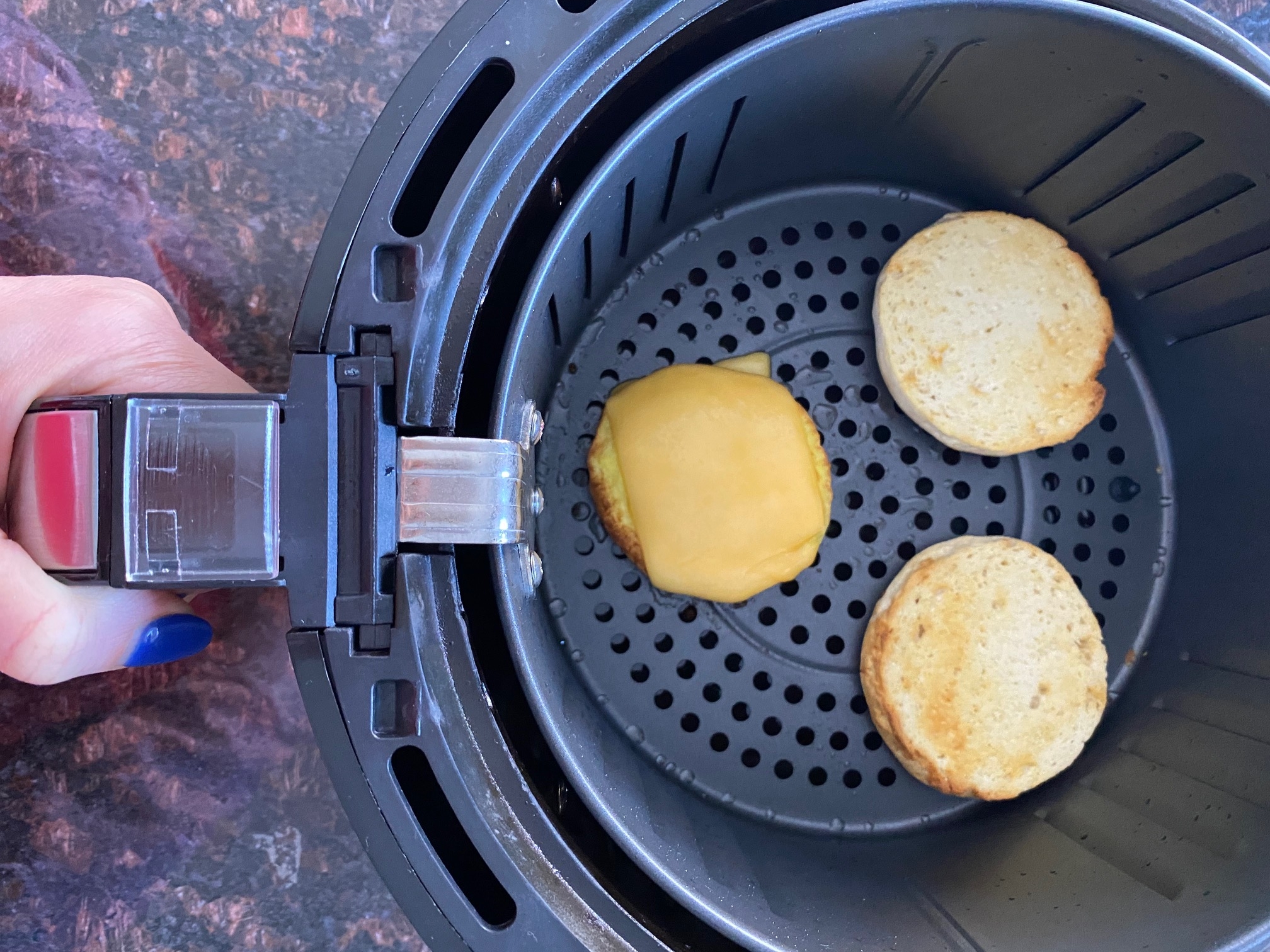 Breakfast sandwich layers in an air fryer.