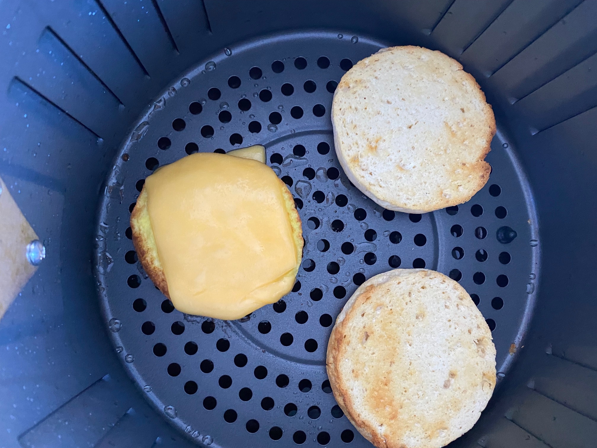 Breakfast sandwich layers in an air fryer.