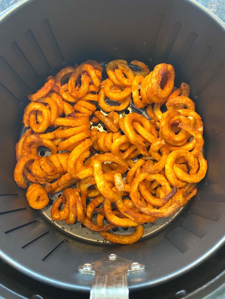 overhead shot of curly fries cooking in the air fryer