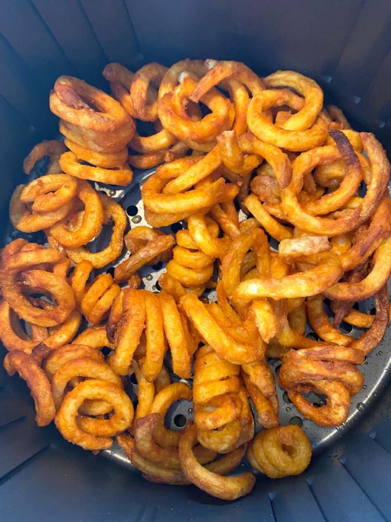 close up of curly fries cooking in the air fryer