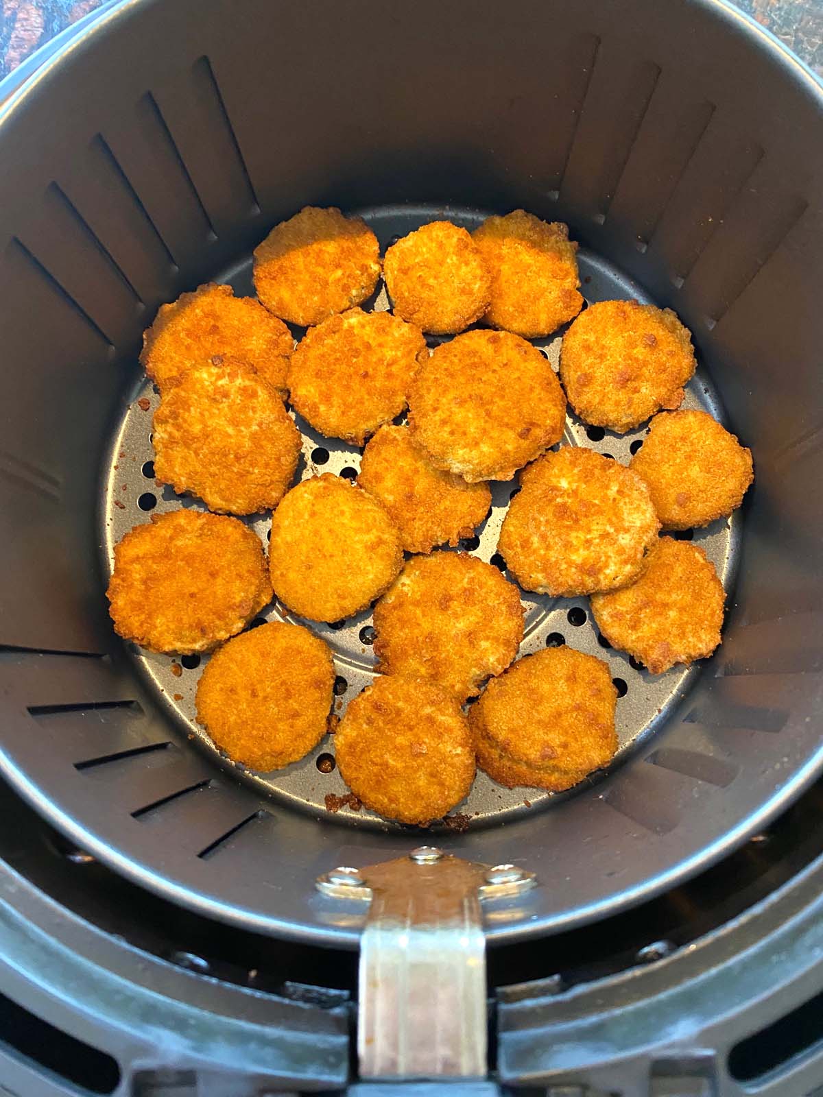 Crispy battered pickles in a single layer of basket.