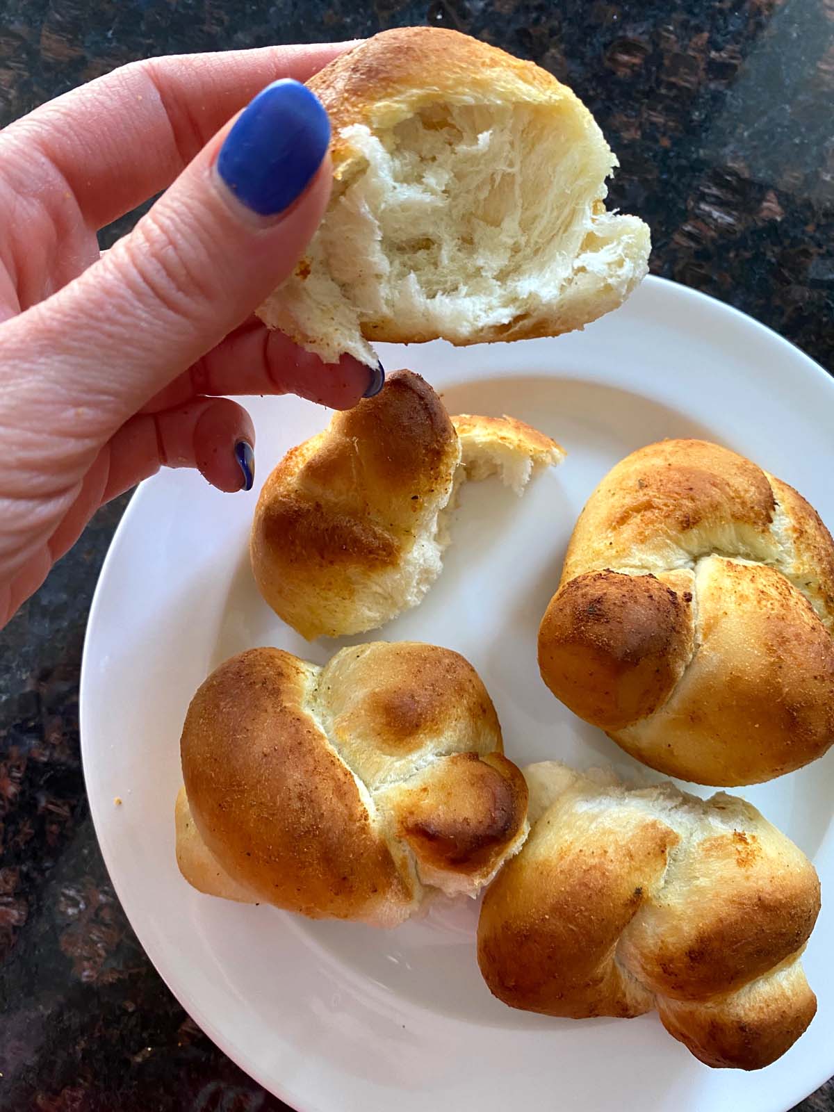 Baked garlic knots on a white plate. 