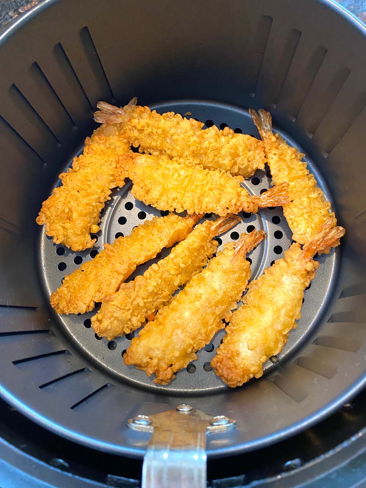 Crispy tempura shrimp cooked in an air fryer basket.