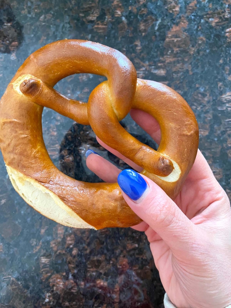 hand holding large soft pretzel cooked in air fryer